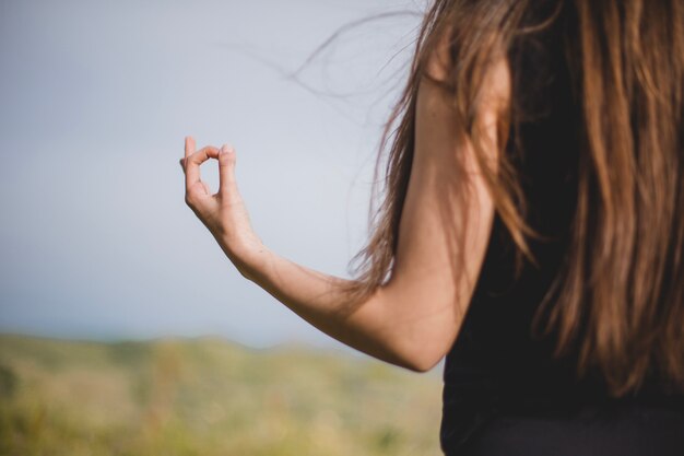 Unrecognizable niña meditando en la naturaleza