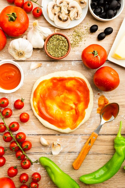 Foto gratuita unte la salsa de tomate sobre la masa de pizza