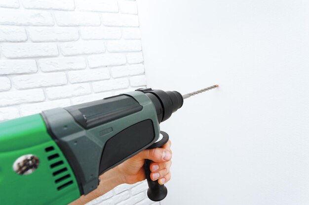 Use un taladro percutor para perforar la pared
