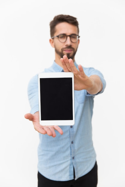 Usuario masculino de la tableta que muestra la pantalla en blanco