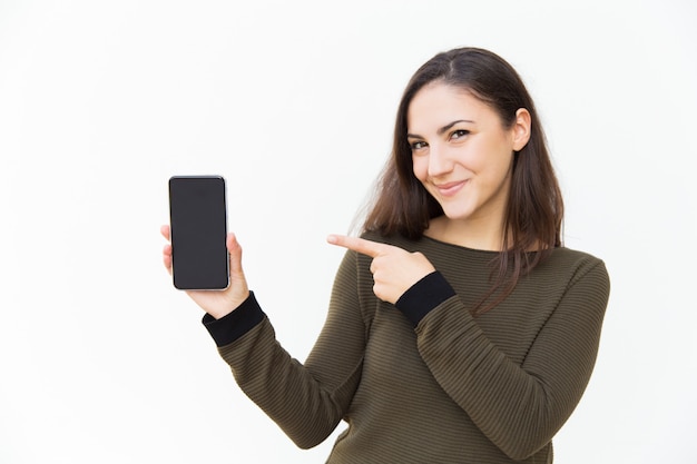 Usuario de teléfono celular alegre feliz apuntando a la pantalla en blanco