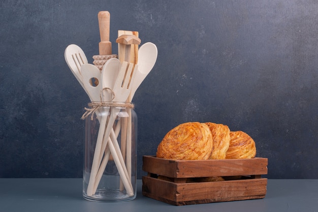 Foto gratuita utensilios de cocina con canasta de madera de gogals sobre mesa de mármol.