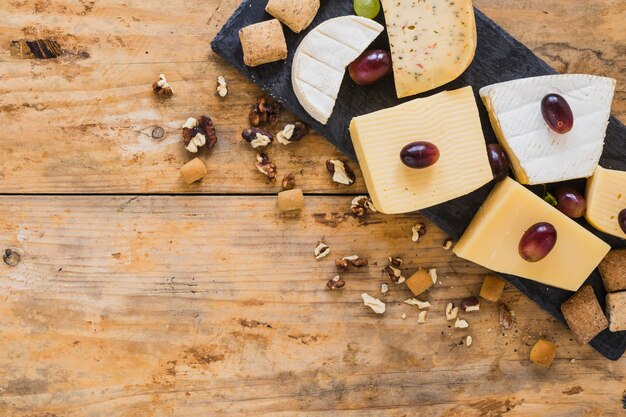 Uvas en bloques de queso con frutos secos en mesa