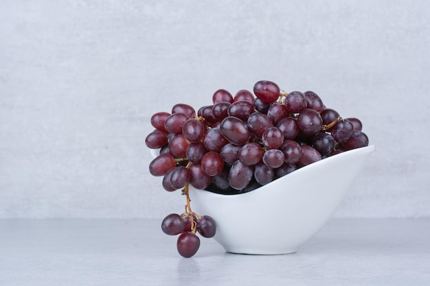 Uvas dulces frescas en plato blanco sobre fondo blanco. Foto de alta calidad