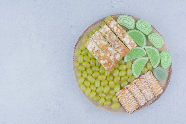 Uvas, galletas y mermeladas sobre plancha de madera.