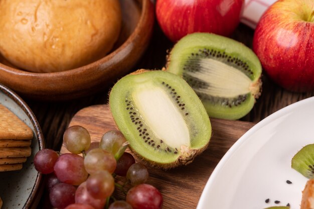 Uvas, kiwi, manzanas y pan en la mesa