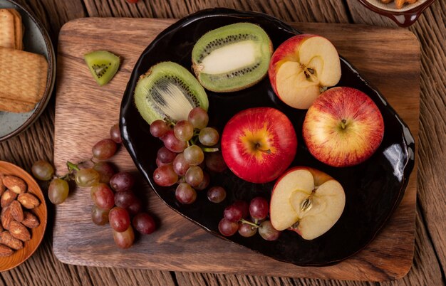 Uvas, kiwi, manzanas y pan en la mesa