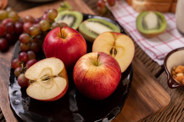 Uvas, kiwi, manzanas y pan en la mesa