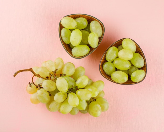 Foto gratuita uvas verdes en cuencos de color rosa.