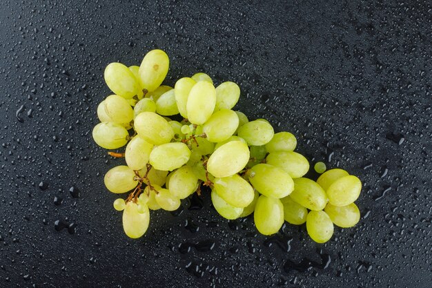 Uvas verdes sobre un gris oscuro.