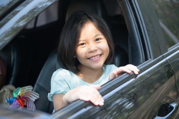 Vacaciones familiares, familia feliz en un viaje por carretera en su automóvil, mamá conduciendo un automóvil mientras su hija está sentada al lado, mamá e hija están viajando. Paseo de verano en automóvil.