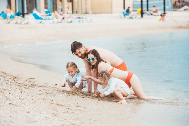 Vacaciones familiares padres e hijos en la orilla del mar día de verano