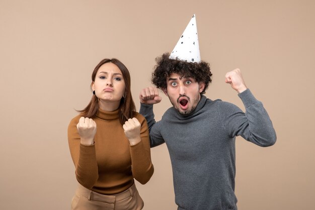 Vacaciones festivas y concepto de fiesta - feliz emocional emocionado orgulloso encantador joven pareja en gris