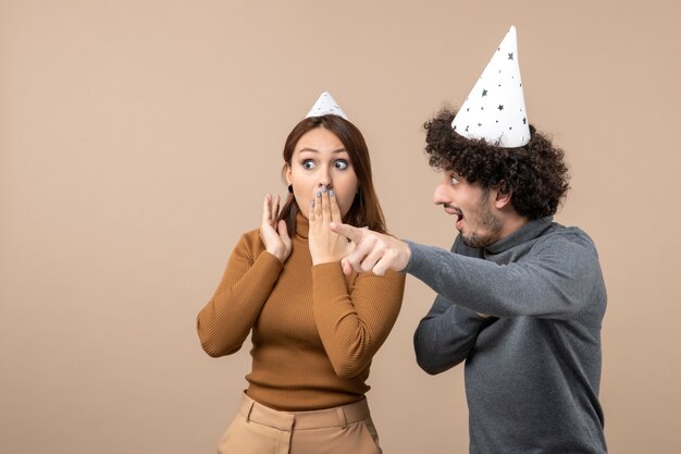 Vacaciones festivas y concepto de fiesta - feliz pareja divertida amorosa mirando algo sorprendido