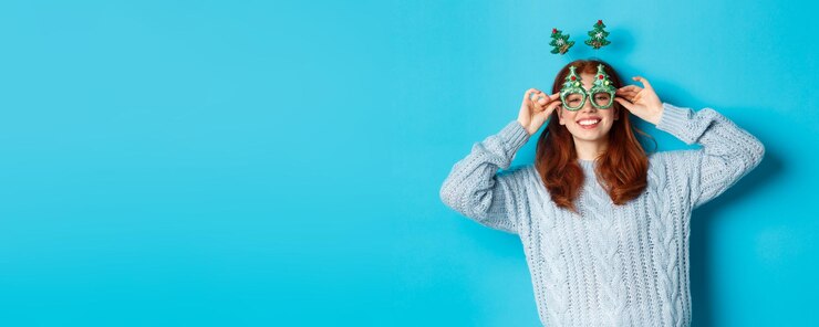 Foto gratuito vacaciones de invierno y concepto de ventas navideñas hermosa modelo pelirroja celebrando ropa de año nuevo