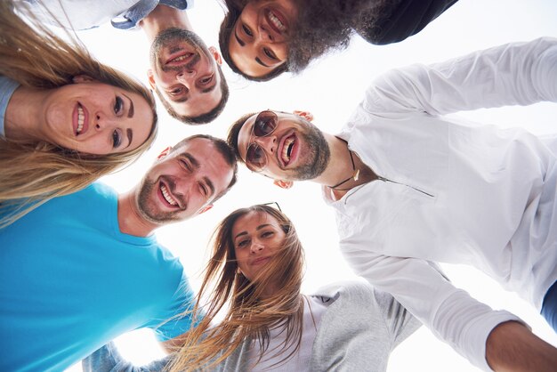 Vacaciones de verano, gente feliz: un grupo de adolescentes mirando hacia abajo con una sonrisa feliz en su rostro.