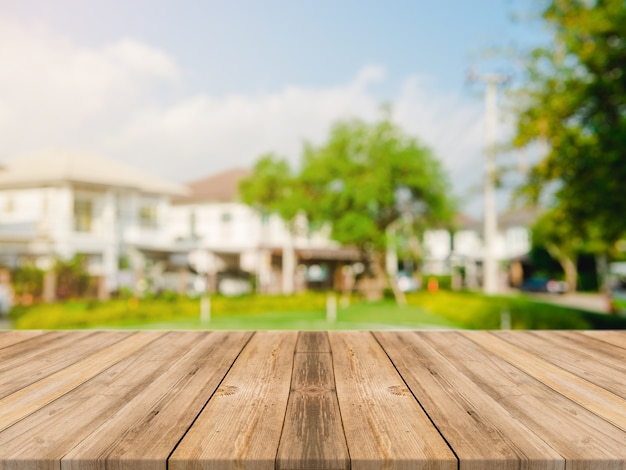 Vaciar la mesa de madera en la parte superior de desenfoque abstracta verde de jardín y la casa en la mañana de fondo.Para la presentación del producto de montaje o el diseño de diseño visual clave