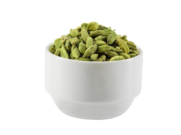 Vainas de cardamomo verde en un recipiente aislado sobre fondo blanco con espacio de copia de texto o imágenes. Se utiliza como saborizante tanto en alimentos como en bebidas, como especias para cocinar y como medicina. Composición del marco, primer plano