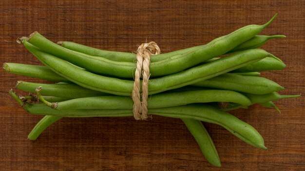 Vainas de guisantes laicos planos en la mesa atada con una cuerda