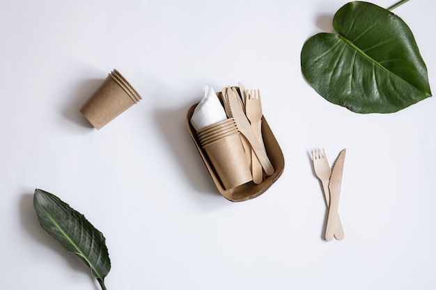 Vajilla ecológica desechable fabricada en madera de bambú y papel. Tazas, cuchillos y tenedores aislados.