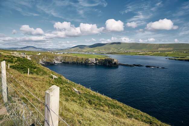 Valentia Island rodeada por el mar bajo la luz del sol y un cielo nublado en Irlanda