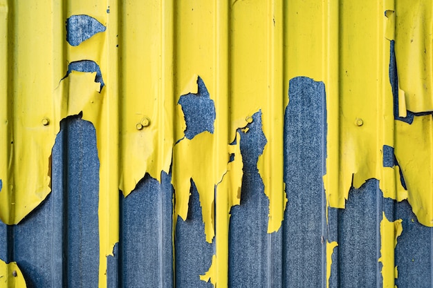 Foto gratuita valla de estaño de hierro pelado amarillo fondo forrado. textura de metal