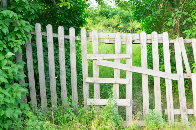 Valla de madera en un jardín lleno de árboles