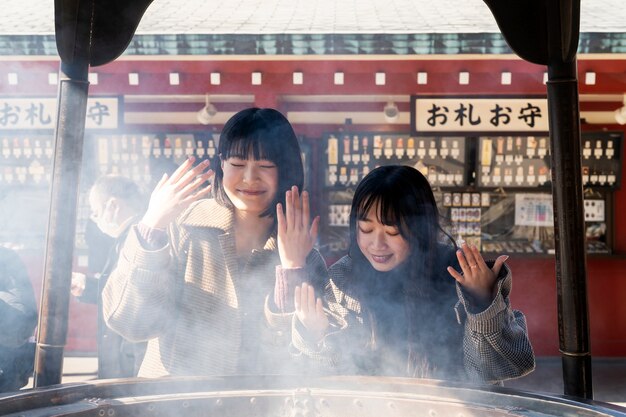 Vapor y mujeres sonrientes de tiro medio.