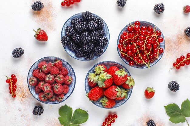 Varias bayas frescas de verano, arándanos, grosellas rojas, fresas, moras, vista superior.