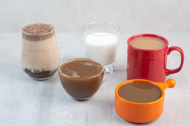 Varias deliciosas tazas de café y leche sobre fondo de piedra. Foto de alta calidad