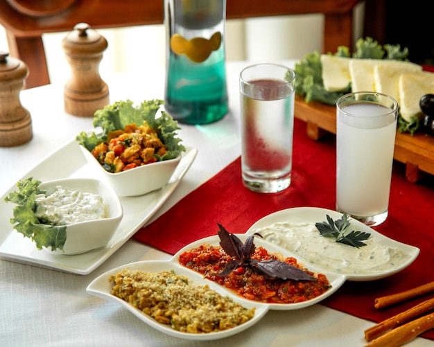 Foto gratuita varias ensaladas con vaso de agua.