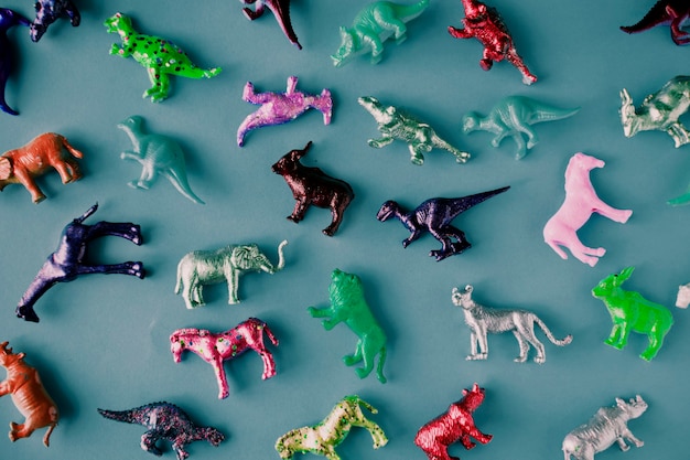 Varias figuras de juguete de animales en una superficie azul