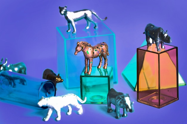 Varias figuras de juguetes de animales con cajas y en un fondo colorido