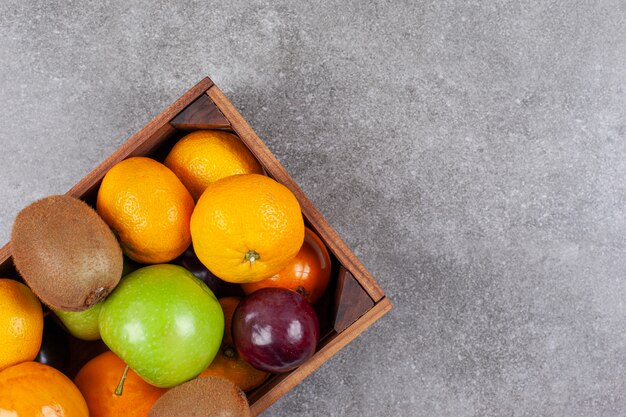 Varias frutas frescas en una canasta de madera