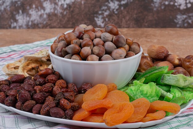 Varias frutas secas y nueces en un plato blanco.