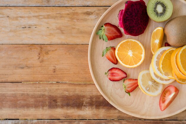 Varias frutas con verduras sobre fondo de madera