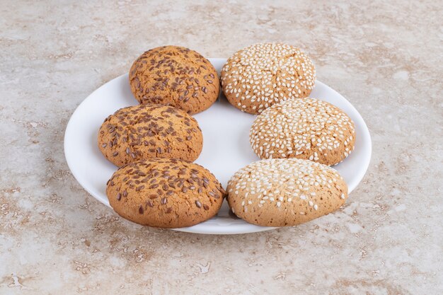 Varias galletas en un plato, sobre la mesa de mármol.