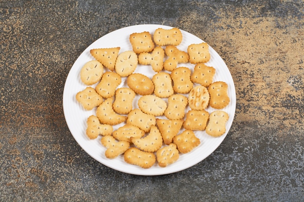 Varias galletas saladas en forma de plato blanco.