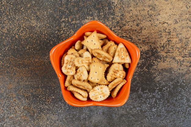 Varias galletas saladas en forma de tazón de naranja.