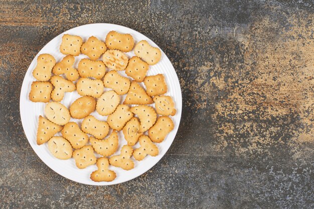 Varias galletas saladas en un plato blanco.