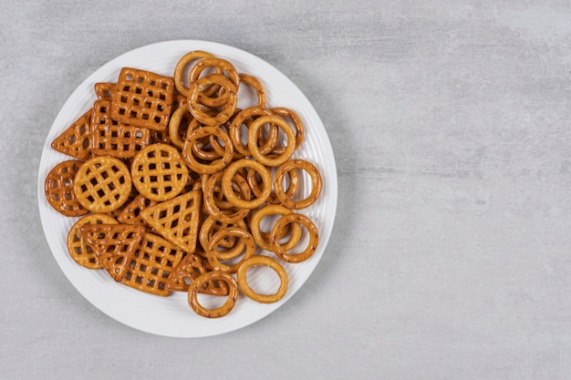 Varias galletas saladas en un plato blanco.