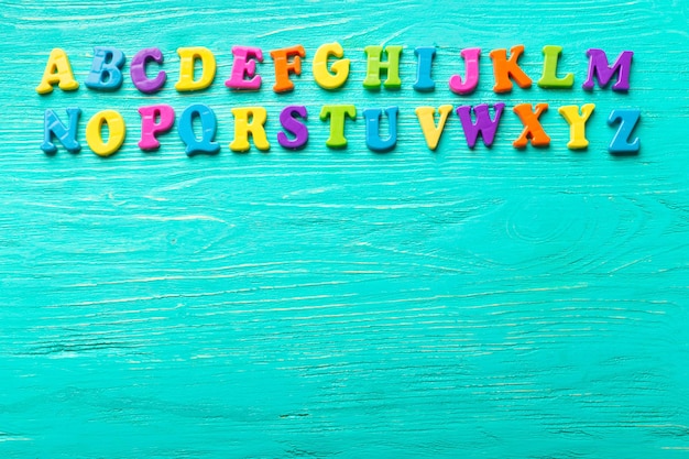 Varias letras de colores sobre mesa de madera