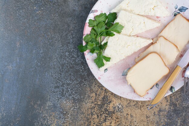 Varias lonchas de queso en un plato con cubiertos.