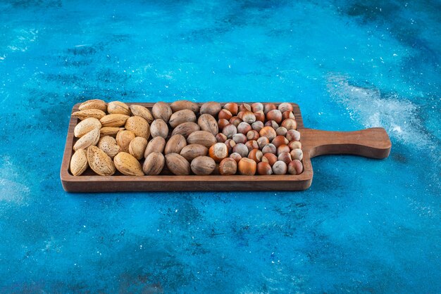 Varias nueces en un tablero, sobre la mesa azul.