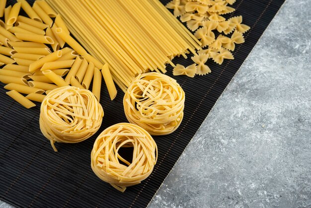 Varias pastas sin cocer en hoja de bambú negro.