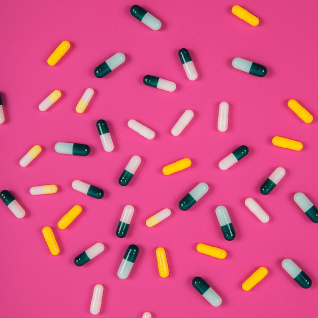 Varias pastillas sobre fondo rosa