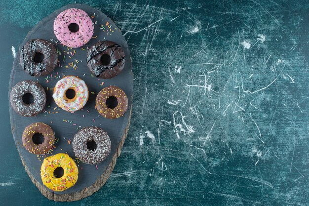 Varias rosquillas en un tablero, sobre el fondo azul. Foto de alta calidad