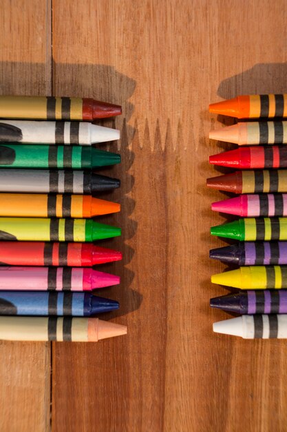 Varias tizas de colores sobre la mesa de madera
