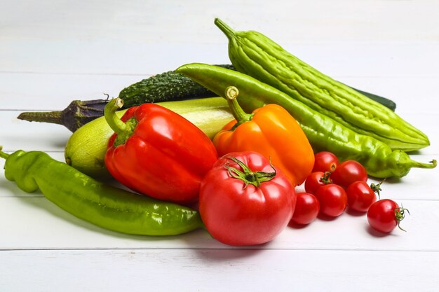 Varias verduras de colores en la mesa de madera blanca