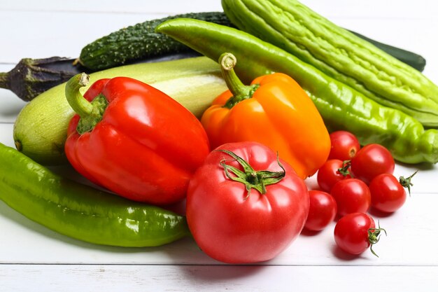 Varias verduras de colores en la mesa de madera blanca